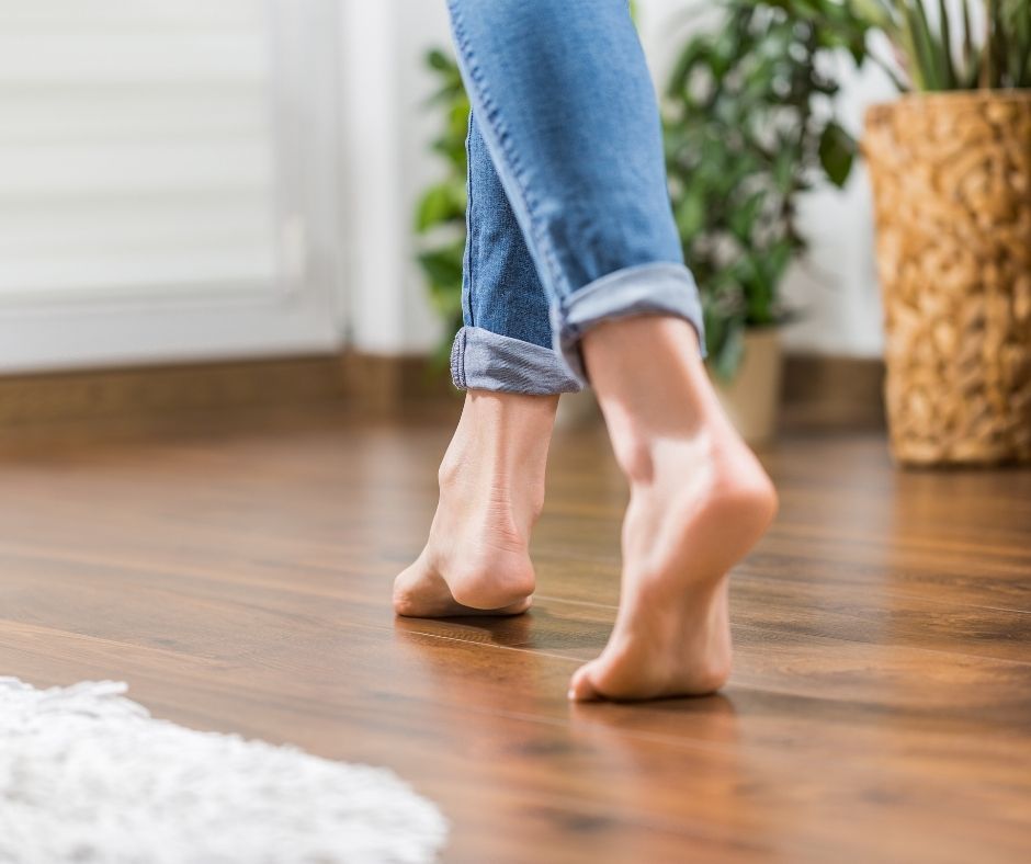 bare footed woman walking on hardwood floors